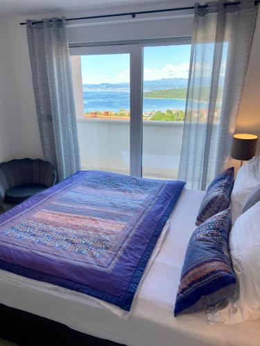 a bedroom with a bed and a large window at Villetta Mia in Njivice