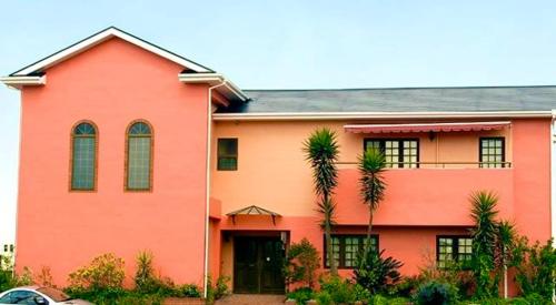 a orange house with palm trees in front of it at Eishinan 栄進庵 in Fuji