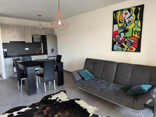 a living room with a couch and a dining room at Sublime Appart T2 in Bastia