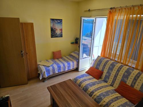a living room with a couch and a bed at Apartmani Jelena in Neum