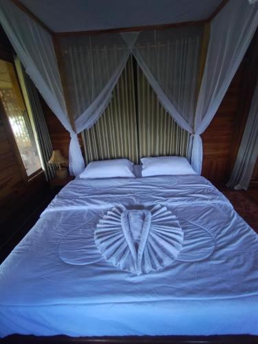 a white bed with a heart made out of pillows at 361 Alam in Rarang