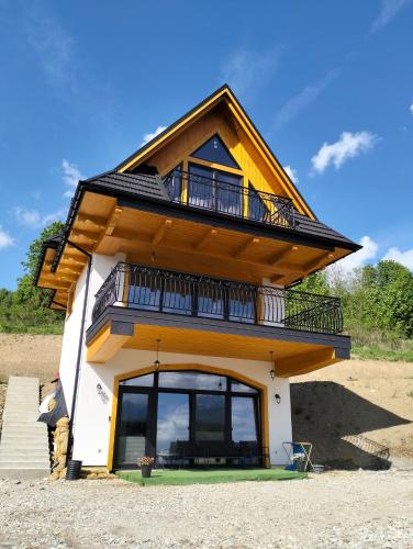 a house with a balcony on top of it at Siedem Światów in Jurgów