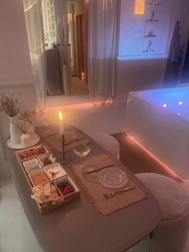 a room with a table with a candle and a tub at Evāra Private Spa & B&B Retreat in Herk-de-Stad