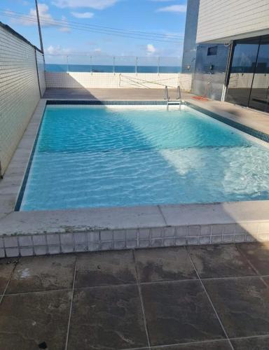a swimming pool with blue water in a building at Apartamento Vista Mar Belli Golden tower in Natal