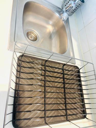 un évier de cuisine avec une grille en métal en dessous dans l'établissement Studio Champs Elysées Ponthieu, à Paris