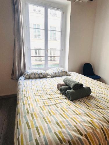 - une chambre avec un lit, 2 serviettes et une fenêtre dans l'établissement Studio Champs Elysées Ponthieu, à Paris