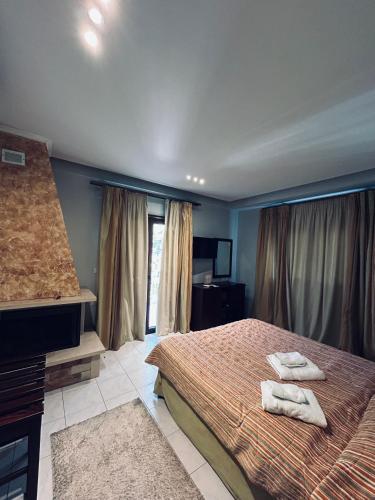a bedroom with a bed with two towels on it at Hotel Athina in Kato Loutraki