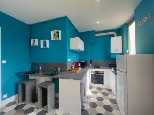 - une cuisine avec des murs bleus, un comptoir et un réfrigérateur dans l'établissement Le VIP, à Vienne