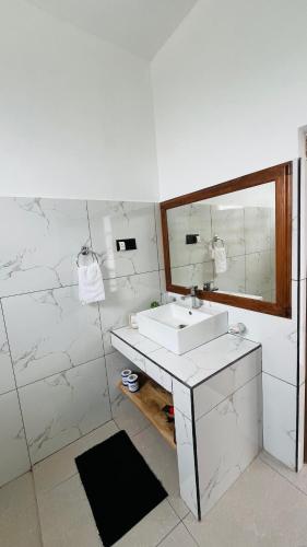 a white bathroom with a sink and a mirror at Mountain Paradise Bliss Guest House in Haputale