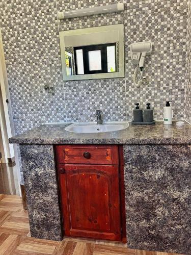 un bagno con lavandino e specchio di Vilea Frangipani Ground Floor 2 bedroom Apartment a Mahe