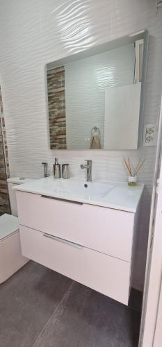 a white bathroom with a sink and a mirror at apartment tenerife south coast in Costa Del Silencio