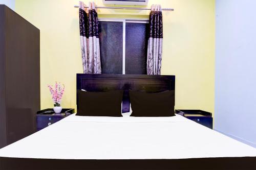 コルカタにあるHotel O The Orchid Residencyの窓のある大きな白いベッドのある寝室