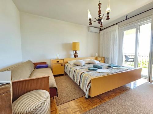 une chambre avec un lit, un canapé et une fenêtre dans l'établissement LEO ROOM 2 NV - Room for 2-3 persons with bathroom, balcony (no kitchen), à Novi Vinodolski