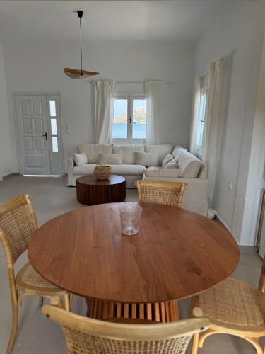 a living room with a wooden table and chairs at Anemelia by the Sea - Lipsi in Lipsoi