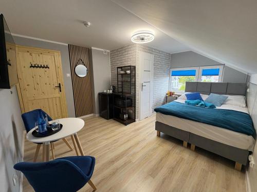 a bedroom with a bed and a table and chairs at Przystań Pod Wieżą in Władysławowo