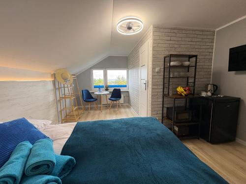 a bedroom with a blue bed and a dining room at Przystań Pod Wieżą in Władysławowo