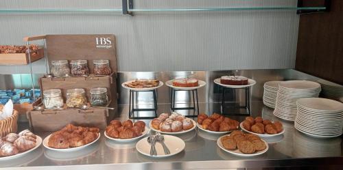 una línea de buffet con diferentes tipos de comida en platos en UNA Hotels La Martella Matera, en Martella