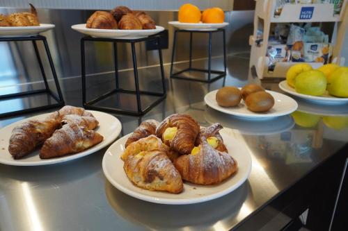 una mesa con platos de bollería y cruasanes en UNA Hotels La Martella Matera, en Martella