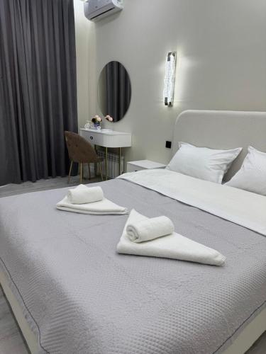 a bedroom with two white towels on a bed at Luxury apartments Capital City in Shymkent