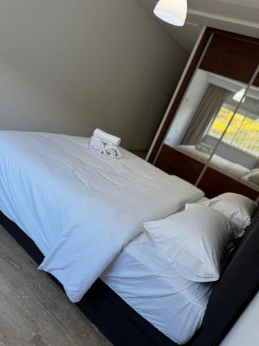a bed with white sheets and pillows next to a window at Séjour Bab Diki in Melîyech