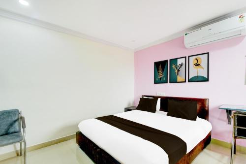 ハイデラバードにあるHotel O Madhu Grand Luxury Roomsのベッドとテーブルと椅子のある寝室