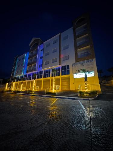 a yellow and white building with blue lights on it at Séjour Bab Diki in Melîyech
