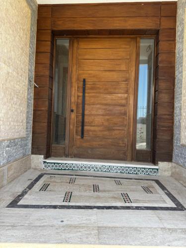 a wooden door on a house with a tile floor at Séjour Bab Diki in Melîyech