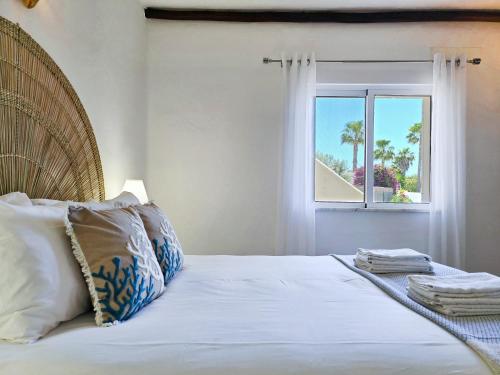 ein Schlafzimmer mit einem großen Bett mit Fenster in der Unterkunft APT QUINTA PARAÍSO - Swimming Pool & Garden in Carvoeiro