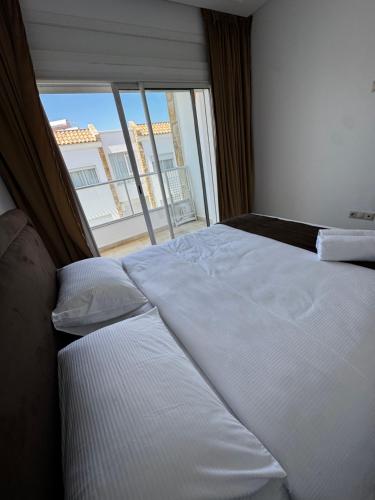 a large white bed in a room with a window at Séjour Bab Diki in Melîyech