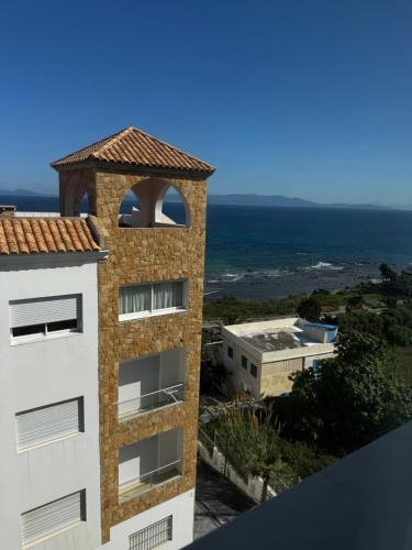 an apartment building with a view of the ocean at Séjour Bab Diki in Melîyech