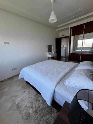 a bedroom with a large white bed in a room at Séjour Bab Diki in Melîyech