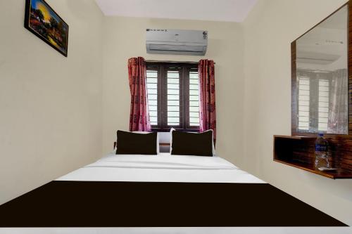 a bed in a room with a window at Hotel O Meera Home Stays - 1 BHK in Golden Rock