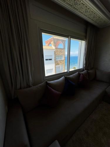 a couch in a room with a window at Séjour Bab Diki in Melîyech