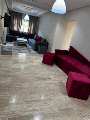 a large living room with a red couch and chairs at Séjour Bab Diki in Melîyech