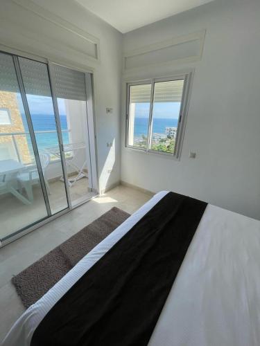 a bedroom with a bed with a view of the ocean at Séjour Bab Diki in Melîyech