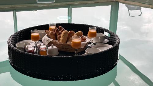 een mand gevuld met brood en glazen sinaasappelsap bij Domaine Léa Chanflaur - Spa - La maison du bonheur in Terraube