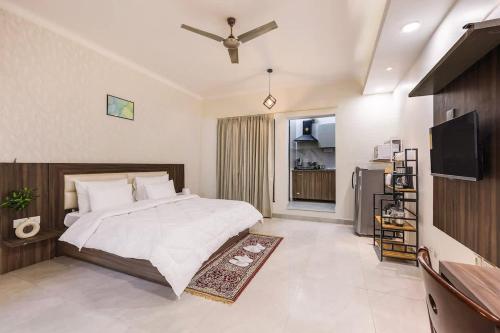 a bedroom with a large bed and a television at Green stays brighter days in Gurgaon