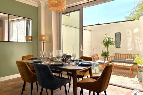 une salle à manger avec une table et des chaises en bois dans l'établissement La Villa Mirabeau, à Deauville