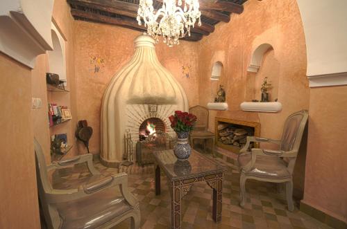 a dining room with a fireplace and a table and chairs at Riad Palais Des Princesses & Spa in Marrakesh