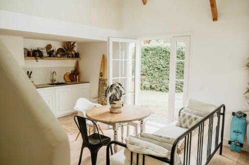 a living room with a table and chairs and a kitchen at LaChillmaisonnette in Labenne