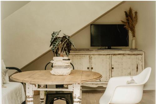 a living room with a table and a tv at LaChillmaisonnette in Labenne