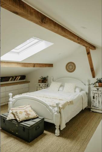a bedroom with a white bed and a skylight at LaChillmaisonnette in Labenne