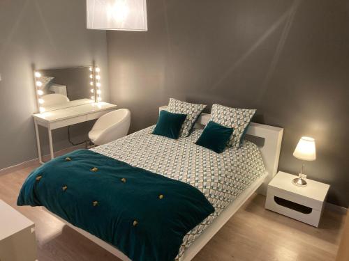 a bedroom with a bed with blue sheets and a desk at Gite chez Isabelle in Villers-le-Lac