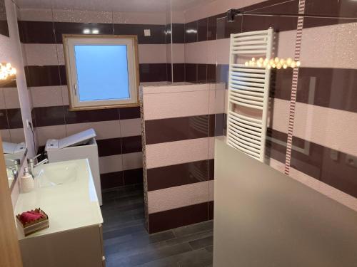 a bathroom with a sink and a window and a mirror at Gite chez Isabelle in Villers-le-Lac