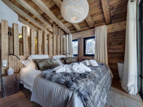 sypialnia z dużym łóżkiem w drewnianym domku w obiekcie Appartement de luxe avec jacuzzi, terrasse et cheminée - 10 personnes - FR-1-567-97 w mieście Val dʼIsère