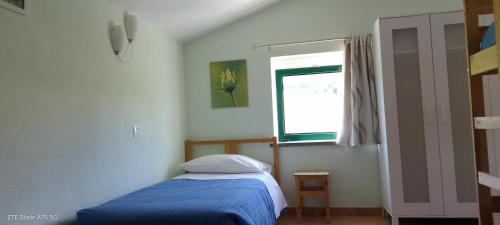 a bedroom with a bed and a window at La Castagna Matta in Albareto