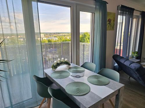 a dining room with a table and a large window at Sun Prague - Stodůlky in Prague
