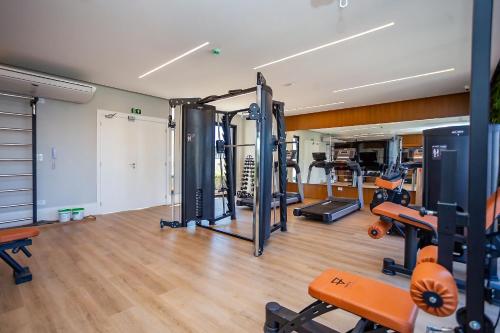 a gym with treadmills and machines in a room at Condomínio Temple Batel | Gonzaga Stays in Curitiba