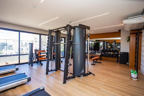 a gym with several treadmills and exercise equipment at Condomínio Temple Batel | Gonzaga Stays in Curitiba