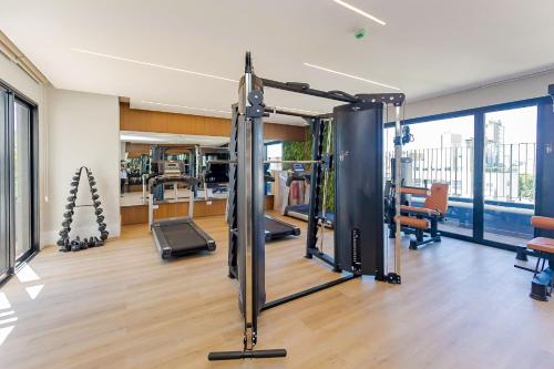 a gym with treadmills and exercise equipment in a building at Condomínio Temple Batel | Gonzaga Stays in Curitiba